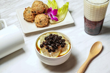 Honey Lemon Aloe vera Aiyu With dace fish balls, Taiwanese red bean ice tea served in dish isolated on marble background side view of taiwan food