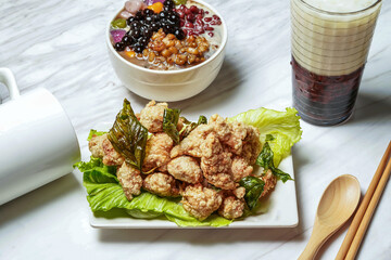 Chengfeng Polang Salt Crispy Chicken with Brown sugar taro balls and grass jelly, Taiwanese red bean ice tea served in dish isolated on marble background side view of taiwan food