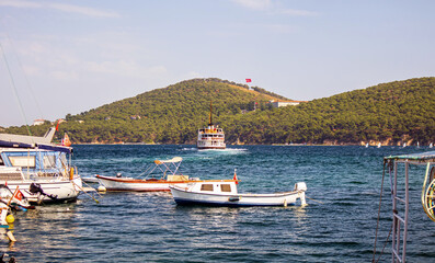 view of forested island and boats in the bay of burgazada island, prince islands, adalar, istanbul