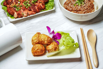 Fried squid balls with pork chop, minced pork rice served in dish isolated on marble background side view of taiwan food