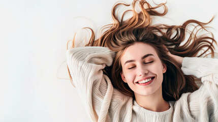 Fototapeta premium Happy young asian woman lying on white background with hands behind head. Copy space