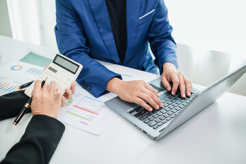 A businessman working on a laptop at his desk in an office environment