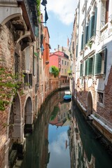 Narrow canal with a small boat in Venice, Italy, surrounded by historic buildings