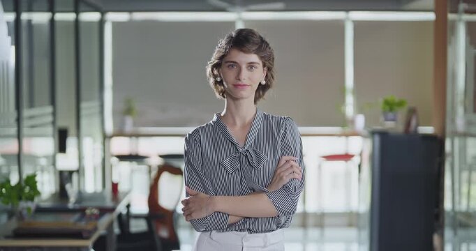Young adult gen z cute girl agent boss standing proud fold hand look cam indoor job office happy french woman lady worker expert staff in formal dress cross arms do pose head shot video day work place