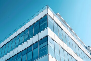 Modern Architectural Marvel: A Glimpse of a Sleek Glass Building Against a Clear Blue Sky