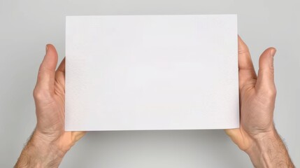 Obraz premium Two hands showing white sheet horizontally