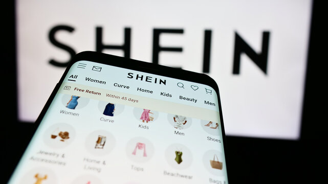 Stuttgart, Germany - 08-16-2024: Smartphone with website of fashion e-commerce company Shein in front of business logo. Focus on top-left of phone display.