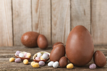 Easter chocolate egg on textured background. Easter celebration concept. Easter chocolate rabbit. Chocolate sweet eggs. Candies on textured wooden table. Space for text.Copy space. Gift. Banner.