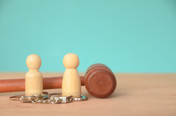 The wooden figures and handcuffs represent individuals involved in legal proceedings.