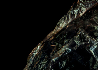 Black plastic abstract background. No plastic bag concept, save world, protect earth. Freeze motion of dark powder exploding. Glossy polyethylene. plastic transparent. Space for text.	
