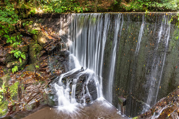 Obraz premium Water dam on a river where a waterfall is produced to feed the water mills for grinding grain, Taramundi, Asturias.