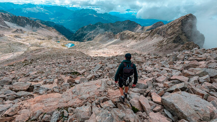 An adventurer travels through the valleys of the Eriste Peak, where the majestic peaks and the lakes of Bagüeñola merge with the alpine vegetation in a unique landscape of the Aragonese Pyrenees.