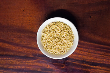 Yellow instant noodles in white ceramic bowl on wooden table, Hot ramen ready to serve, Chinese food, Japanese food, Ready to eat food,Asian food

