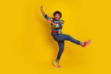 Full size photo of pretty young guy dancing have fun wear trendy colorful outfit isolated on yellow color background