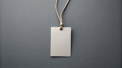 Empty layout on grey background. Common blank label name tag hanging on neck with thread