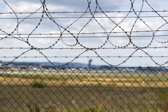 Detailaufnahme eines Sicherheitszauns mit Stacheldraht um das Gel&auml;nde des  Airport N&uuml;rnberg. 