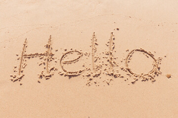 the inscription hello  on the seashore with palm trees