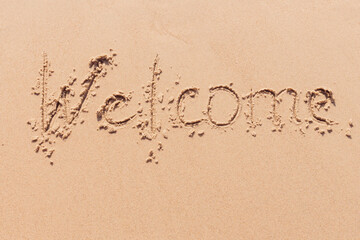 inscription welcome  on the seashore with palm trees