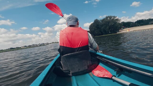 Man In A Life Jacket Canoeing On A Lake, Engaging In Active Outdoor Water Sports