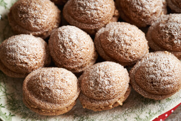 Baked homemade Christmas cookies in the form of nuts filled with cream and dusted with sugar