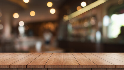 Empty wooden table top with lights bokeh on blur restaurant background.