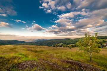 Obraz premium Meadows with sunset in Krusne mountains in evening in Nova Ves v Horach village