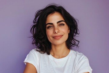 Fototapeta premium Confident young woman with short dark hair and a warm smile against a lavender backdrop