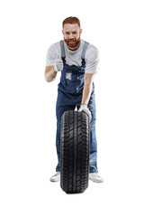 Smiling handsome car mechanic with new tire on white isolated background. Concept store of auto...