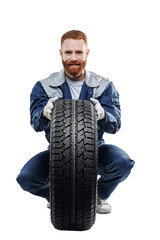 Smiling handsome car mechanic with new tire on white isolated background. Concept store of auto...