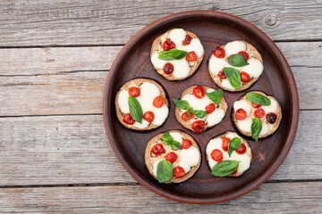 Italian mini pizza . Aubergine (eggplant ) with mozzarella cheese and basil . On rustic background