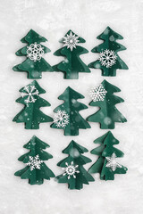 Winter Holidays decor, Christmas trees from green craft paper, Christmas and New Year flat lay. Handmade fir decorated snowflakes on white fur background. Top view creative trend pattern, snow