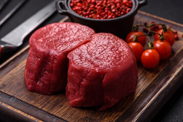 Fresh juicy raw beef medallions with salt and spices