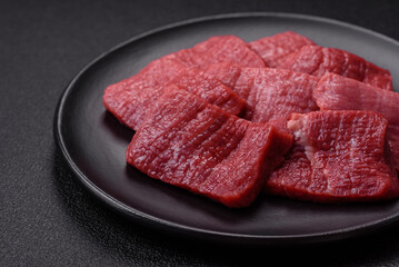 Juicy fresh raw beef meat with salt, spices and herbs