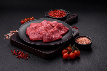 Juicy fresh raw beef meat with salt, spices and herbs