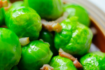 A plate of green brussels sprouts with bacon on top