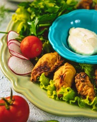 Fried gyoza dumplings served on green plate with dipping sauce