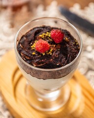 Delicious tiramisu dessert with cocoa powder and raspberries on top