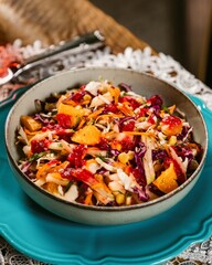 Delicious coleslaw salad with orange, strawberry and red cabbage being served on a turquoise plate