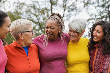 Group of multi generational women hugging each other at city park - Community and multiracial people concept - Focus on african woman face