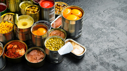 Assortment of canned preserves food in tin open cans: fish, beans, vegetables and fruits. Food...