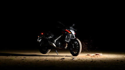 Fototapeta premium raising motorcycle which fallen on ground in dark night at isolated place
