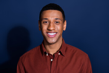 Portrait of young man beaming smile wear brown shirt isolated on dark blue color background