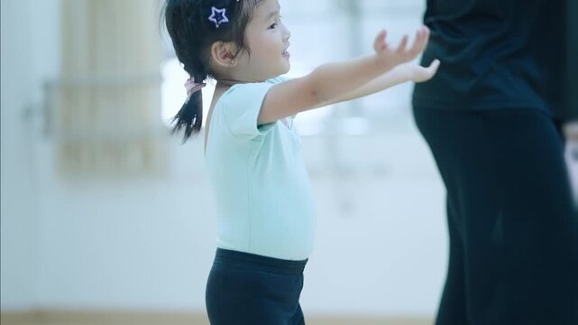 Adorable asian girl practicing in a dance studio classroom. Happy kid student in jazzdance outfir, learning a lesson of balancing choreograpy moves. Hobby Activity exercisenfor young chidren