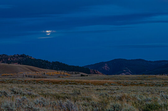 Jackson Hole Valley at dush with the moon peeking through the clouds