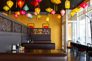 Interior of a vietnamese cafe with traditional vietnamese lantern lamps. Hieroglyphs translate as...