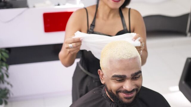 african american client with yellow hai  and hairdresser working at hair dyeing.MOV