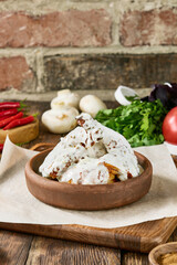 Authentic Georgian Garlic Chicken Served in a Traditional Ketsi with Fresh Herbs and Vegetables