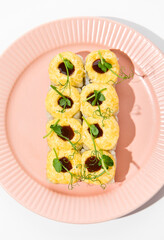 Baked Sushi Roll with Cheese Topping and Unagi Sauce on a Pink Plate