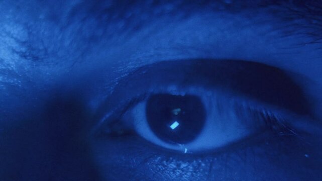 Close-up of an eye in blue light