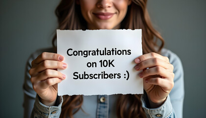 Woman holding congratulations on 10K subscribers sign celebrating milestone
